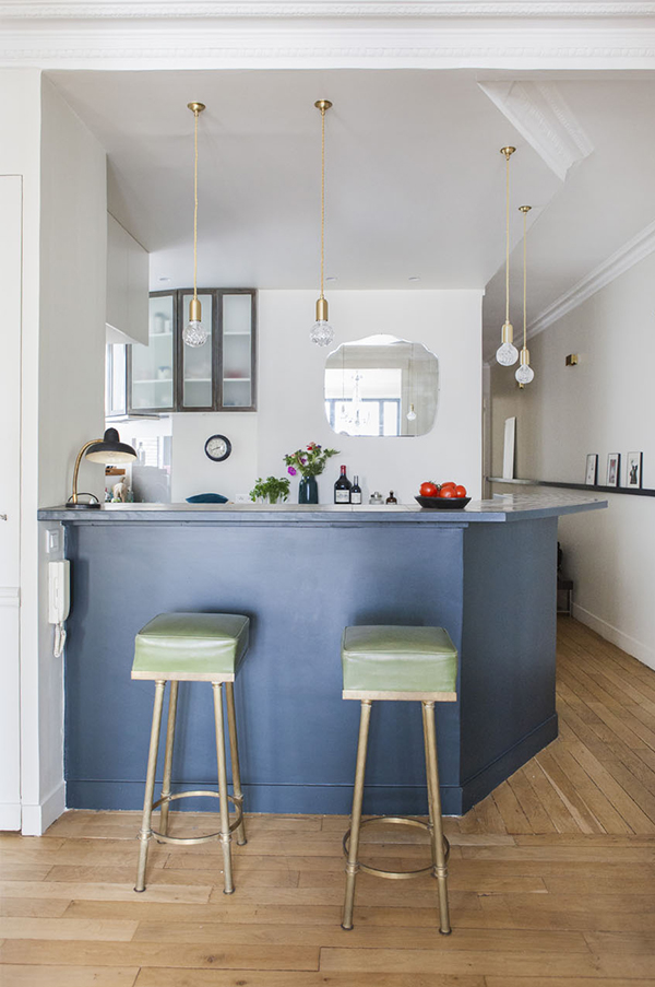 There's a bar space with a navy bar stand, gilded bulb lamps and chic stools with gilded legs and green leather There's a bar space with a navy bar stand, gilded bulb lamps and chic stools with gilded legs and green leather