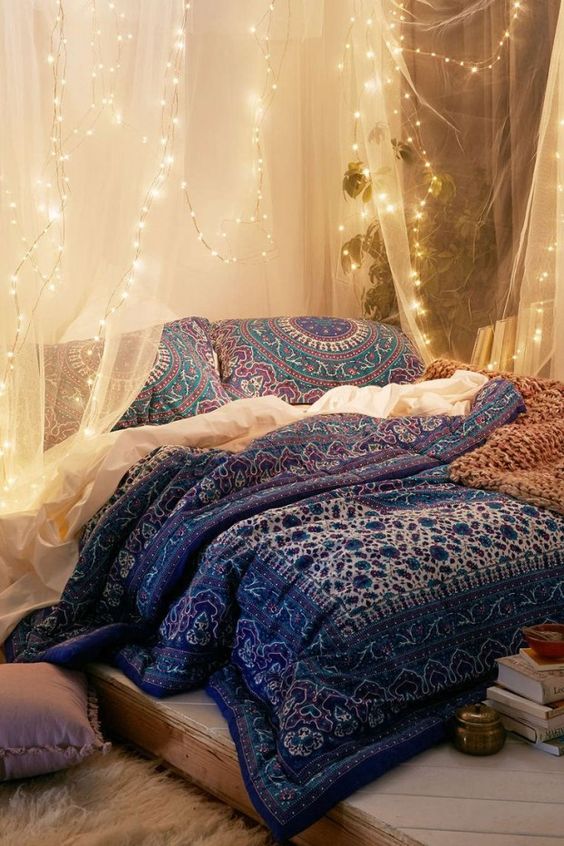 airy fabric canopy over the bed with string lights attached for a boho bedroom
