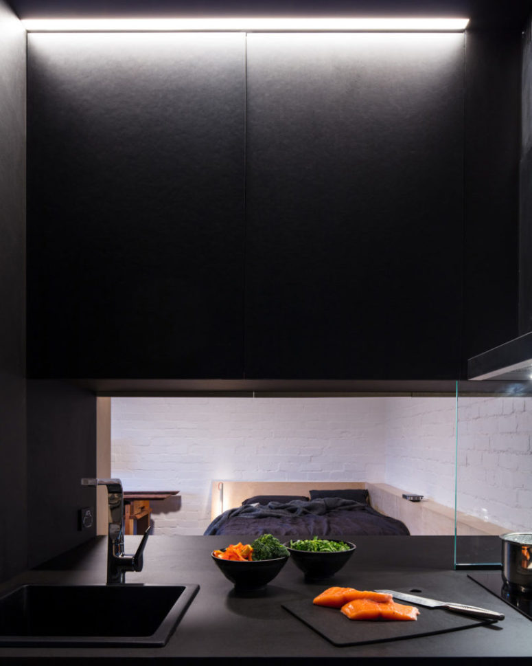 The kitchen is all black and features a pass through window to the room to make eating and having drinks comfier The kitchen is all-black and features a pass through window to the room to make eating and having drinks comfier