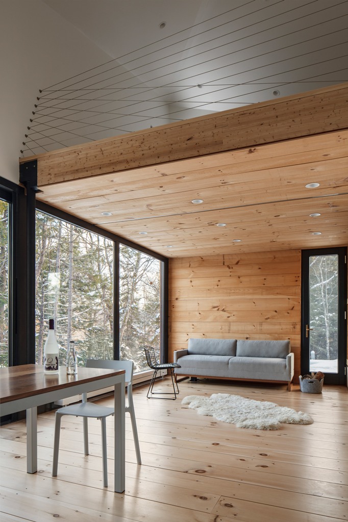 united open space in a forest cabin The living and dining space are united in one, there are panoramic windows to enjoy the views