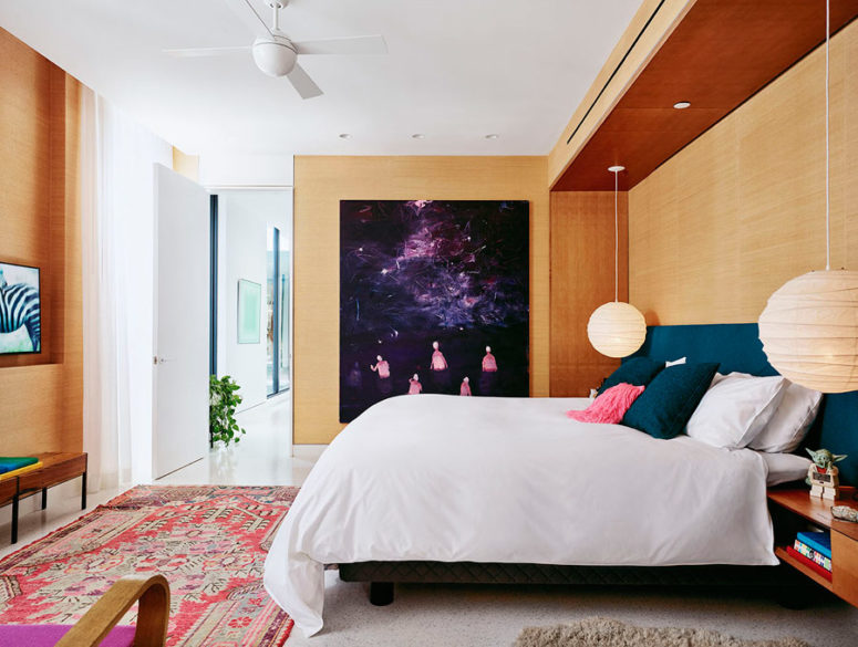 The master bedroom is done with light colored wood, an upholstered wall and a very bold artwork that catches an eye The master bedroom is done with light-colored wood, an upholstered wall and a very bold artwork that catches an eye