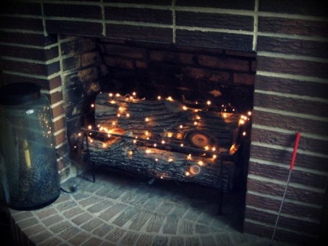 put firewood and then add a string or two of twinkle lights in the fireplace to add a soft glow to the room
