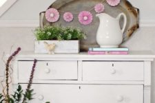 07 a vintage sideboard console, potted flowers and a cute pink paper fan garland