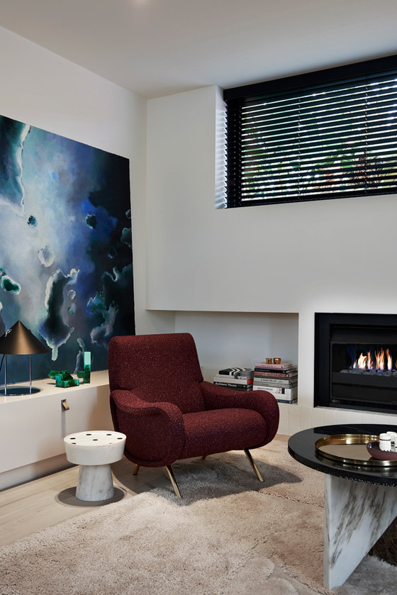 living room with a built in storage The storage is built-in, and there are some bold artworks and accessories that make the space cooler