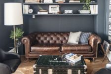 08 a brown leather Chesterfield and a black chest add an industrial touch to the space
