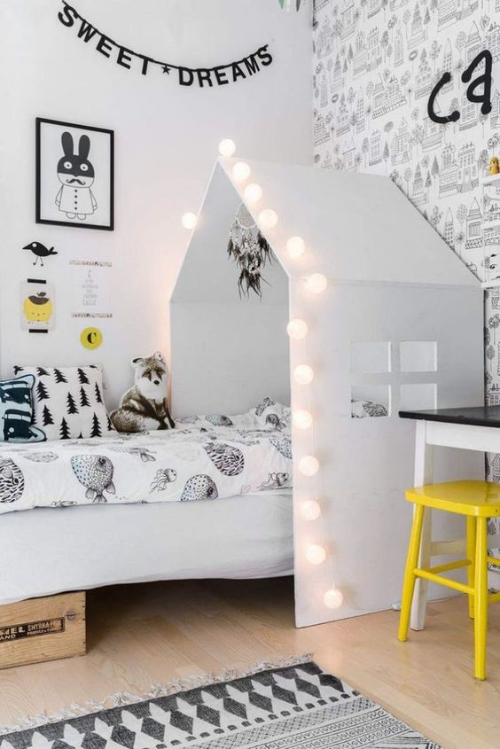 a house-shaped bed with string lights framing to add more light to this sleeping nook