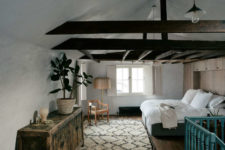 09 The bedroom is done with dark wooden beams, an antique sideboard and rather contemporary furniture and rugs