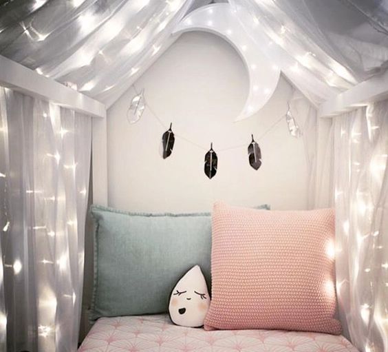 a sheer bed cnaopy with lights and a moon over the bed for a dreamy sleeping space