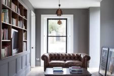 12 a laconic home library with a unique coffee table and a brown leather sofa