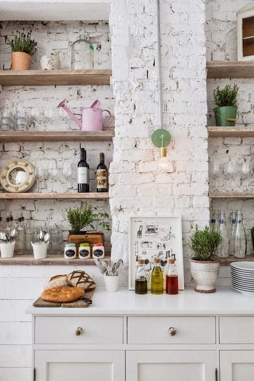 the kitchen is done with rough exposed white brick walls that make it eye-catchy