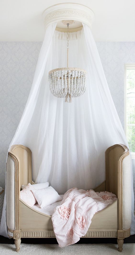 a little girl's sleeping space is accented with a cute chandelier that makes it more glam