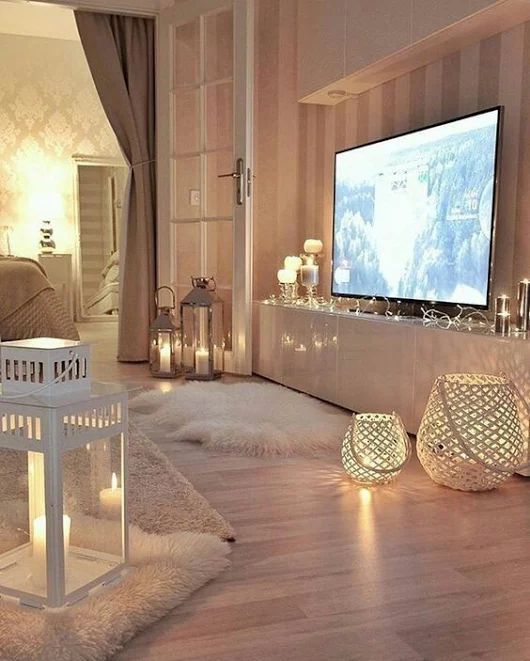 a large TV highlighted with string lights and lots of candle lanterns