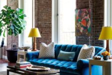 17 a colorful living room with industrial touches and a bold blue Chesterfield sofa