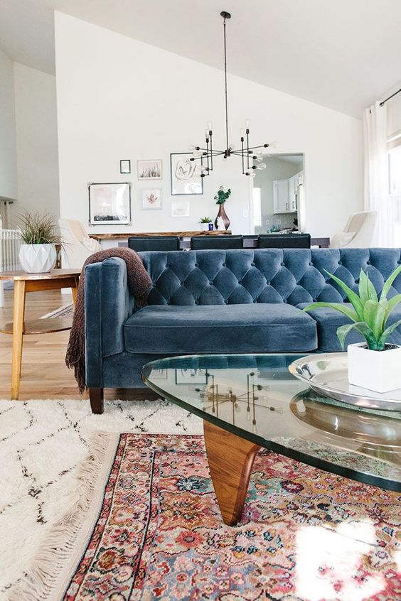 a farmhouse boho space with a muted blue Chesterfield sofa that works as a space divider, too