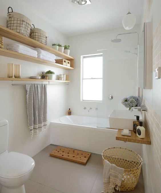 light-colored wooden box and open shelving add a warm touch to the bathroom
