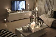 18 string lights on a shelf over the TV make an accent on this zone and candles add romance