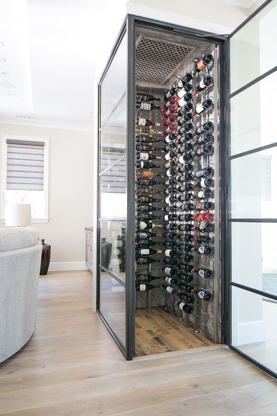 a chic small wine cellar highlighted with framed glass walls to keep a proper temperature inside