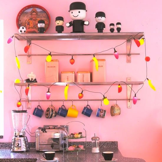 fun vintage fruity string lights on a shelf add a whimsy touch and a fun feel to this colorful kitchen