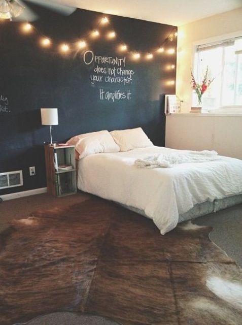 string lights over the bed cheer up the chalkboard wall and make the space cooler