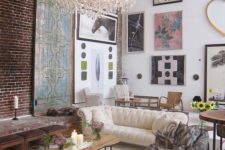 25 an art-filled double height living room with a creamy Chesterfield and a large crystal chandelier