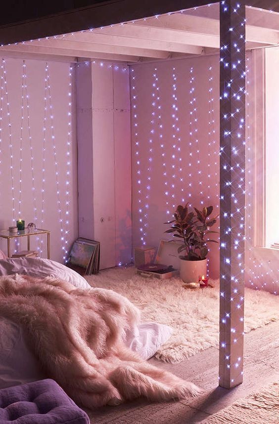 galaxy string lights coverign the walls and beams of a small bedroom to fill it with light