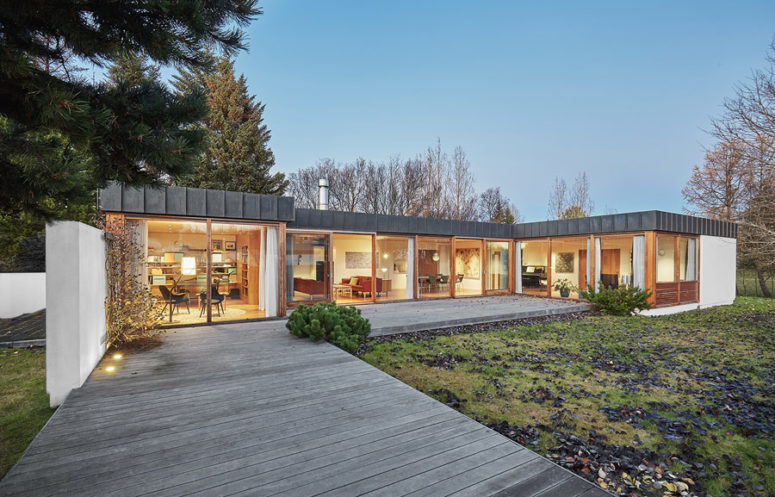 This 1960s home is done with a picturesque roof and traditionally as a long one storey volume with extensive glazing