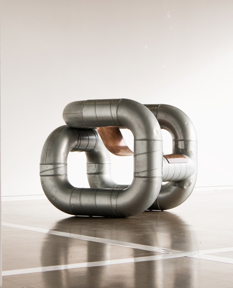 The chair features thick metal pipes and a copper seat that are connected with elbows taken from the designer's studio The chair features thick metal pipes and a copper seat that are connected with elbows taken from the designer's studio