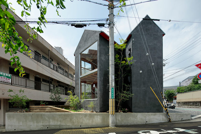 The house is clad with dark grey stucco, which gives it an character and there's a tree in between the parts