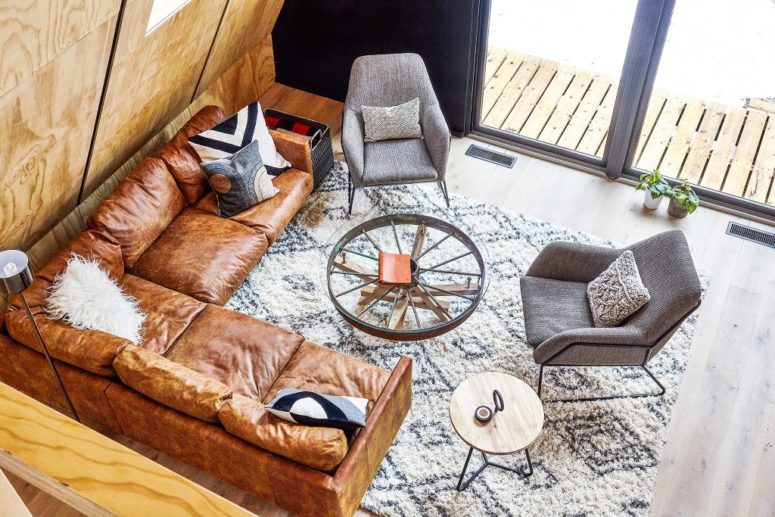 The living room is done with an L shaped brown leather sofa, there are comfy chairs and a couple of rustic coffee tables The living room is done with an L-shaped brown leather sofa, there are comfy chairs and a couple of rustic coffee tables