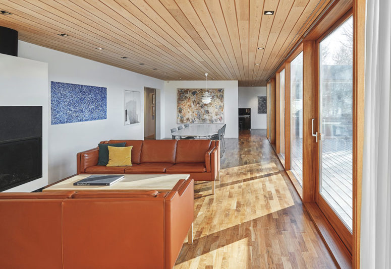 The main open layout comprises a living and a dining space, bold abstract artworks and cool amber leather sofas for the sitting space The main open layout comprises a living and a dining space, bold abstract artworks and cool amber leather sofas for the sitting space
