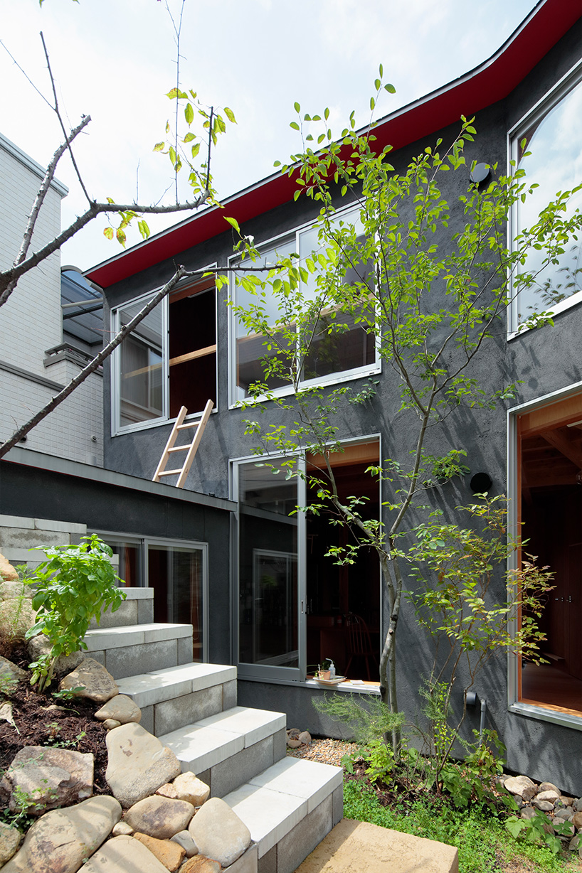 Greenery and rocks look very interesting in front of a modern dark grey home