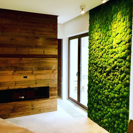 a fresh moss wall and a reclaimed fireplace wall bring a strong natural and relaxing fele to the space