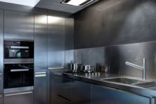 03 a fully stainless steel kitchen with a matching backsplash for a moody yet contemporary feel