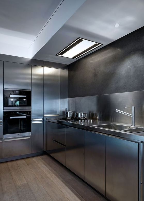 a fully stainless steel kitchen with a matching backsplash for a moody yet contemporary feel