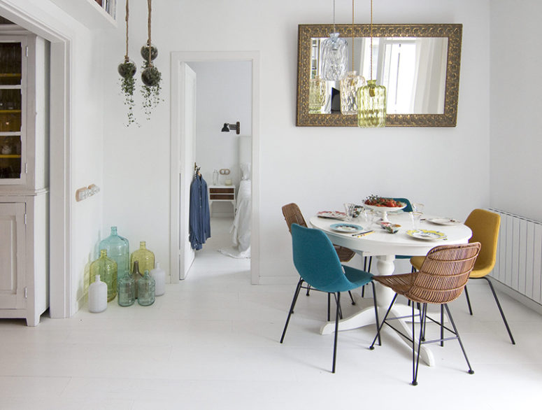 The dining space is done with mismatching chairs, a round table and a vintage mirror