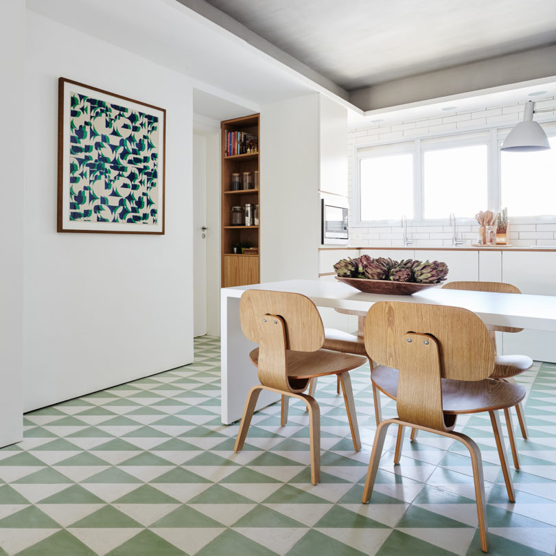 The floors are clad with geometric tiles in green and white, and there's a matching artwork