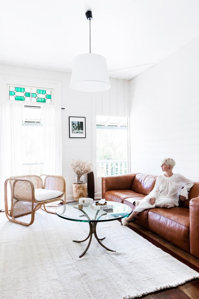 The living room is done with mid-century modern furniture, a brown leather sofa and some mosaics that adds to the decor