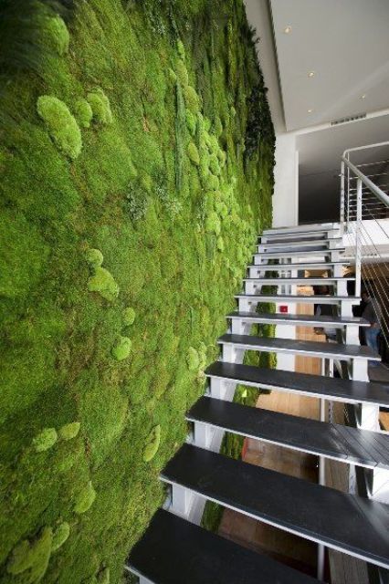 a fresh moss wall next to the staircase creates a feel of an indoor garden
