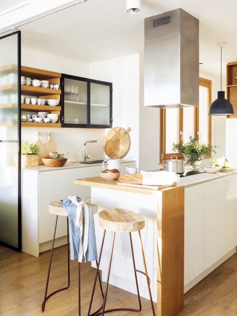 There are just two cabinets and a kitchen island with a cooktop and a breakfast space