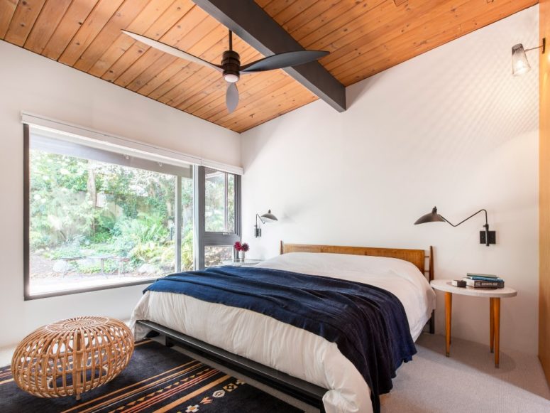 The bedroom features a large window for views and light, and mid century modern furniture to finish off the look The bedroom features a large window for views and light, and mid-century modern furniture to finish off the look