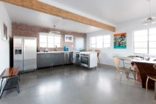 06 The kitchen and dining space comprise one space with wooden beams, an exposed brick wall and metal cabinets