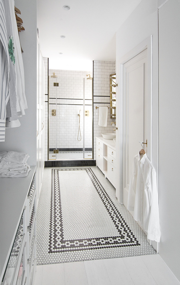 The master bathroom is done with black and white tiles and some brass touches for an elegant vintage feel