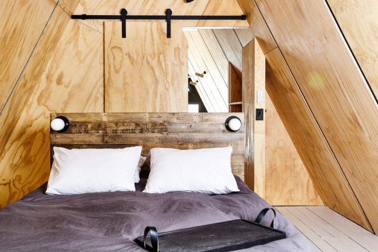 The master bedroom is clad with plywood, there's a barn door and a reclaimed wood bed, there's nothing unnecessary The master bedroom is clad with plywood, there's a barn door and a reclaimed wood bed, there's nothing unnecessary