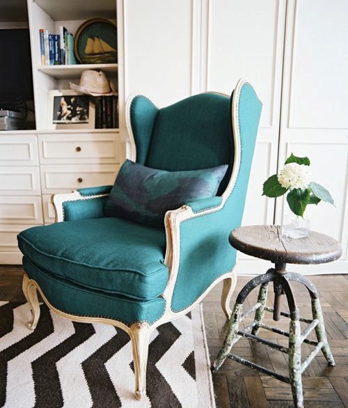 a vintage dark green wingback with light-colored wooden framing is a gorgeous statement piece