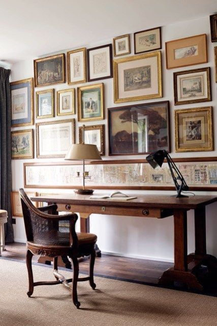 a vintage home office with a gallery wall that takes the whole wall, mismatched frames create a catchy look