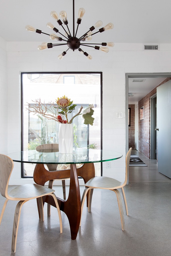 The breakfast space is done with a glass tabletop and sculptural chairs and table legs