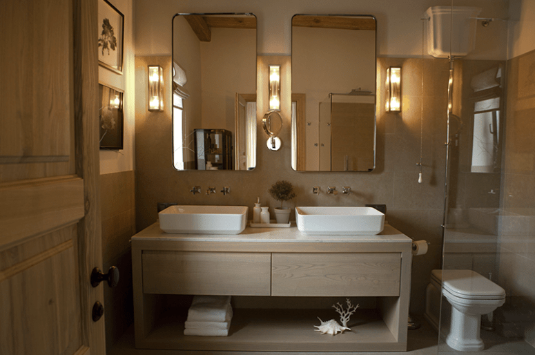 The master bathroom is clad with light colored tiles and wooden vanity, there's a shower and a double sink The master bathroom is clad with light-colored tiles and wooden vanity, there's a shower and a double sink