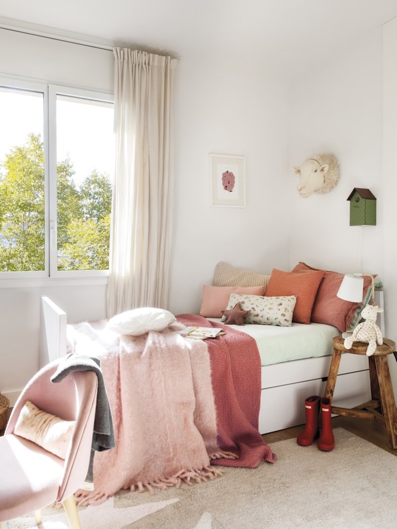 The girls' bedroom is done in red and pinks, with layered textiles and some rustic touches