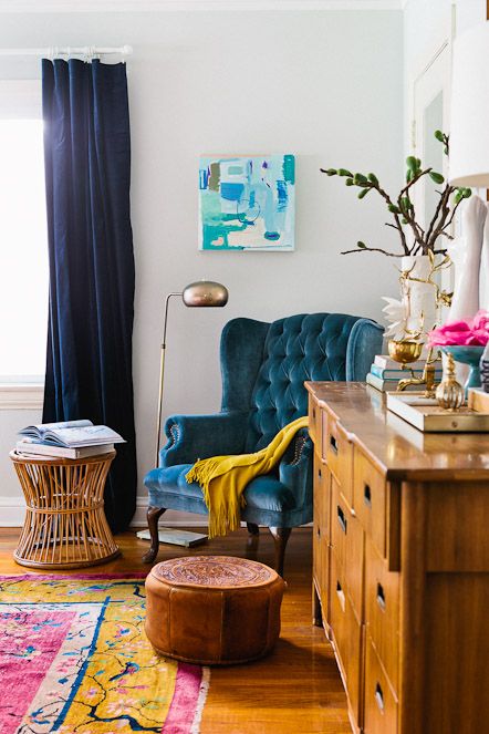 a teal tufted velvet chair is a great fit for a modern boho space like this one