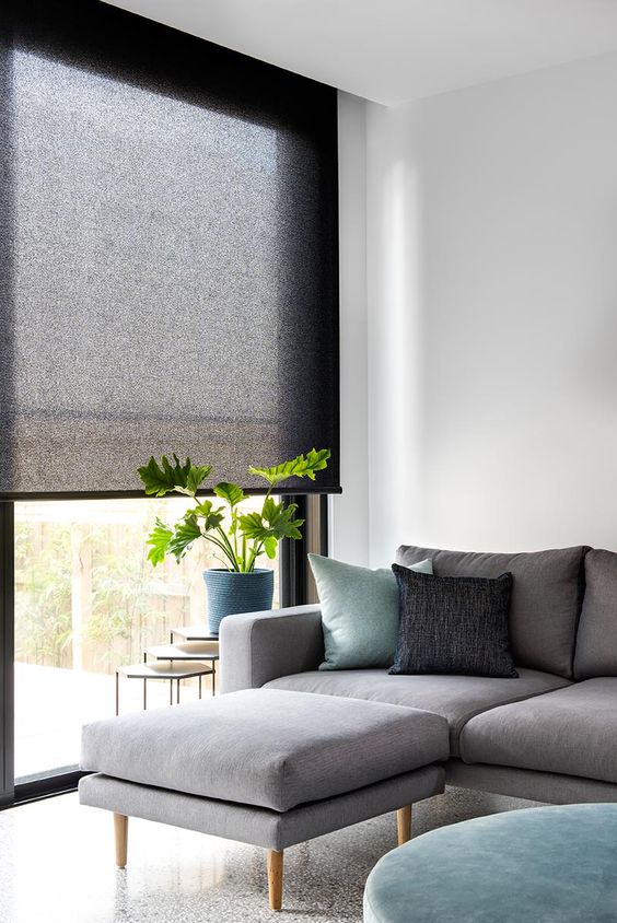 a roller shade of translucent black fabric highlights the style of the room and keeps the excessive light away